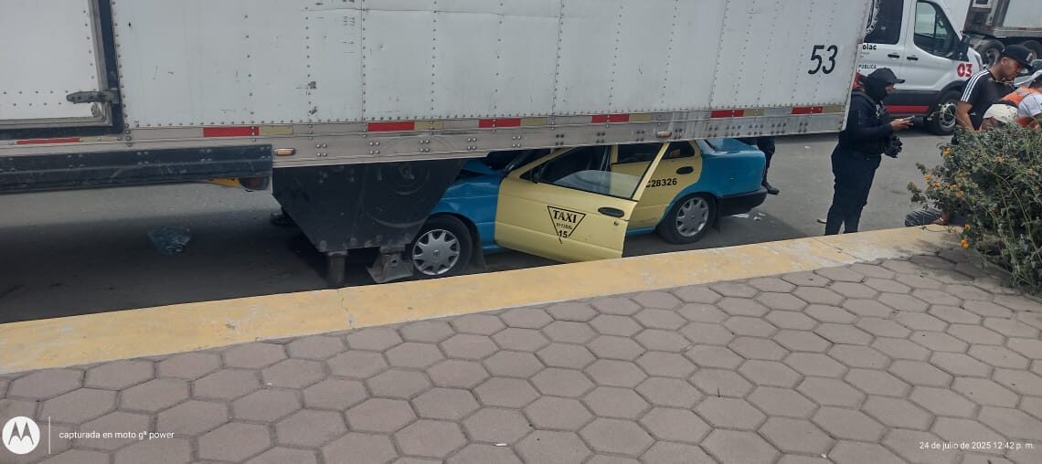 Taxista vive para contarla al quedar con su taxi incrustado debajo de un remolque en Quecholac