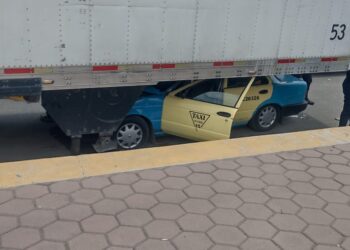 Taxista vive para contarla al quedar con su taxi incrustado debajo de un remolque en Quecholac